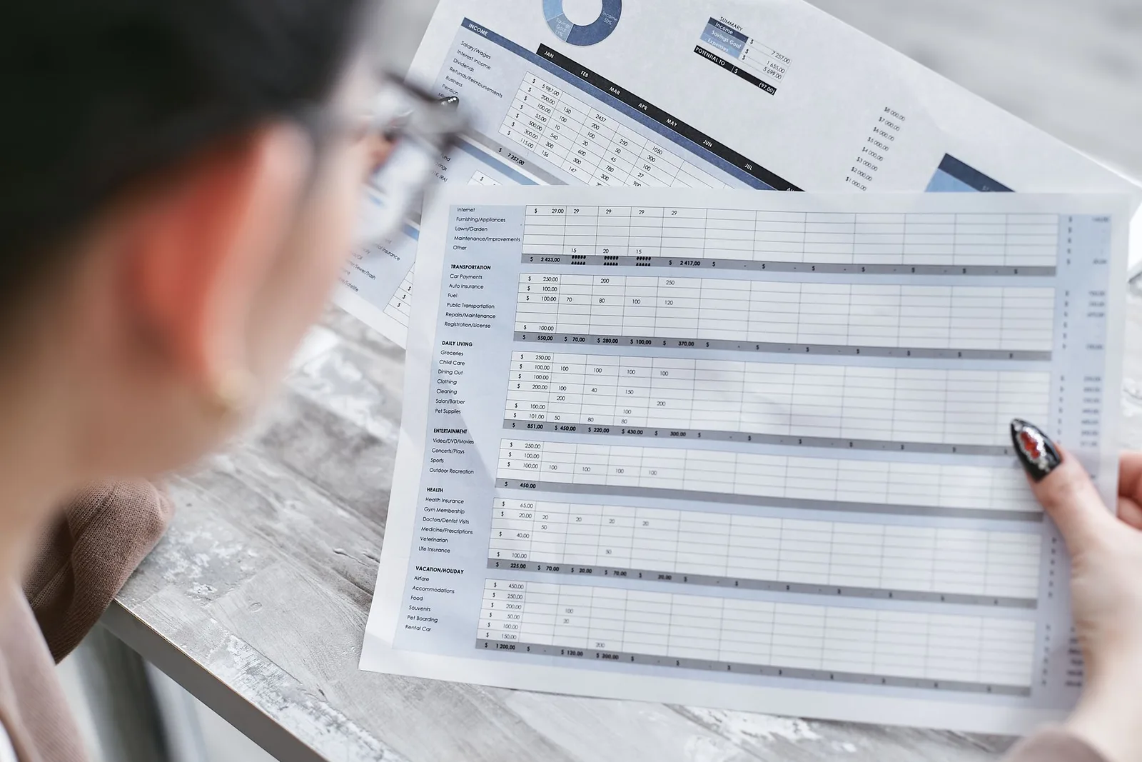 Founder reviewing a financial forecast with printed charts beside a laptop