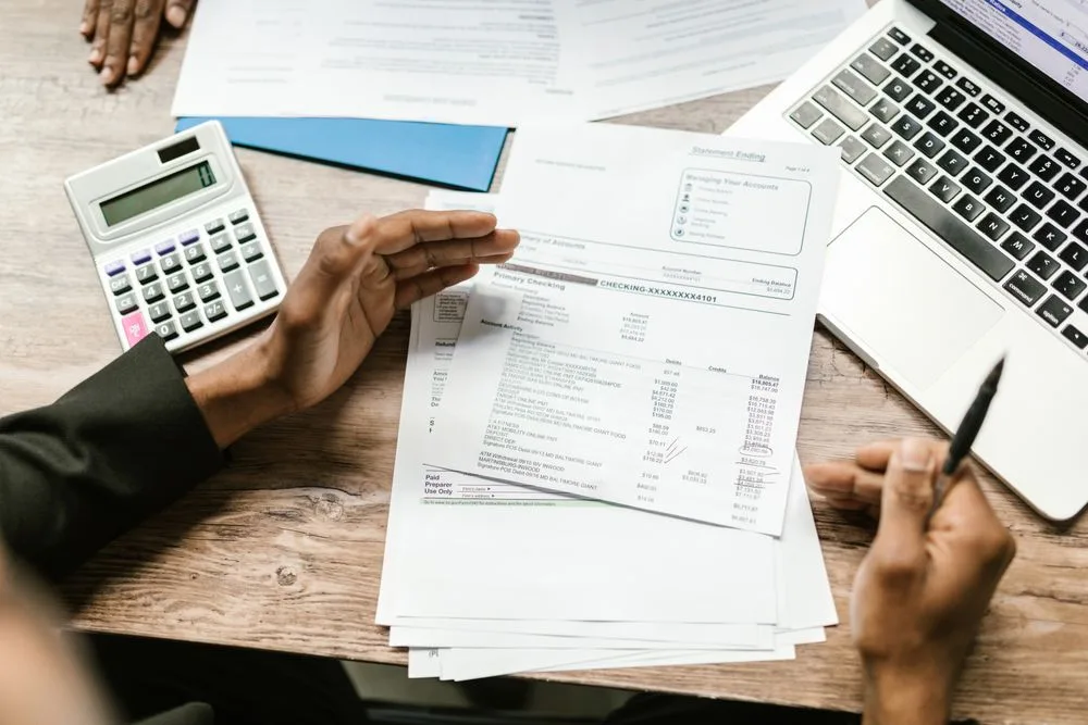 Reviewing financial statements with a laptop and calculator