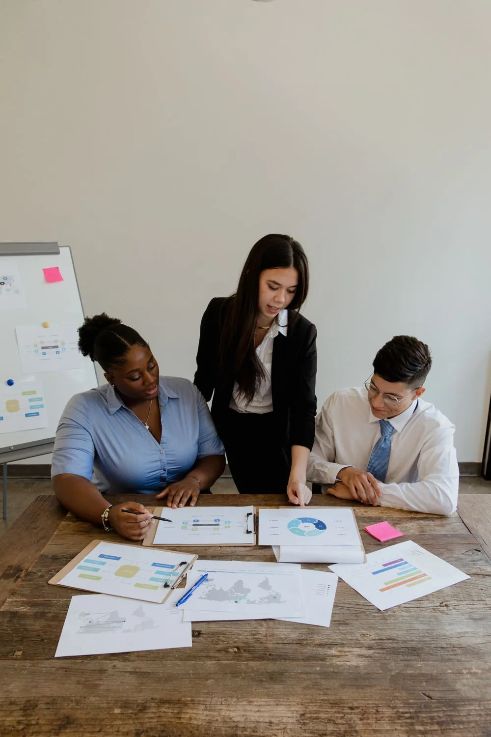 Business team reviewing charts and financial reports around a meeting table